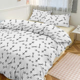 Bedding set with black bone pattern on white fabric in a bedroom setting.