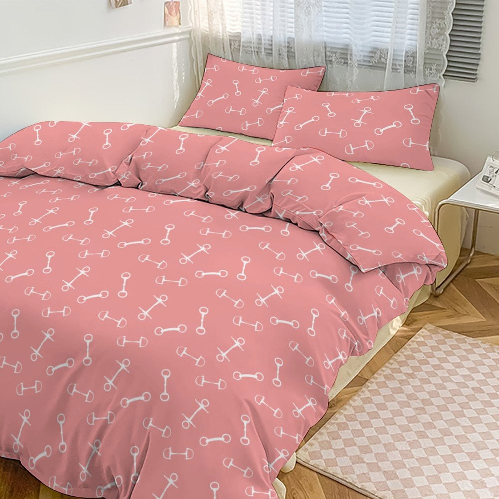 Pink bedspread with white patterns on a bed in a room.