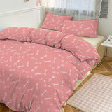 Pink bedspread with white patterns on a bed in a room.