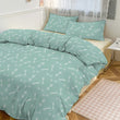Teal bedding set with bone pattern on a bed in a bedroom.