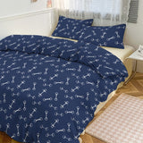 Navy blue bedding set with white bone pattern on a bed in a bedroom.