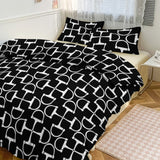 Black and white patterned bedding set on a bed in a bedroom.