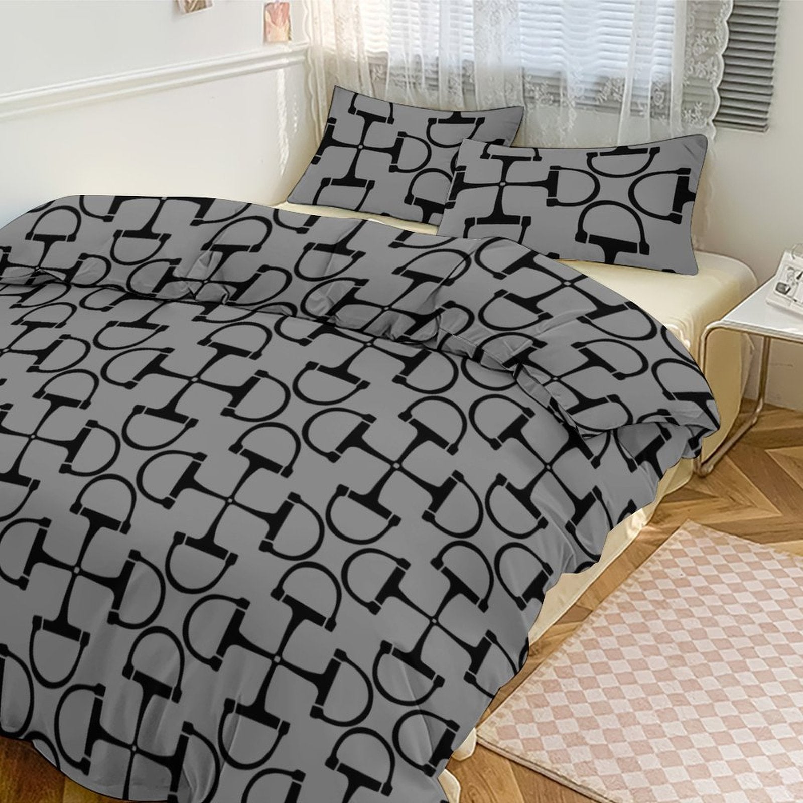 Gray bedding set with black geometric pattern on a bed in a bedroom.