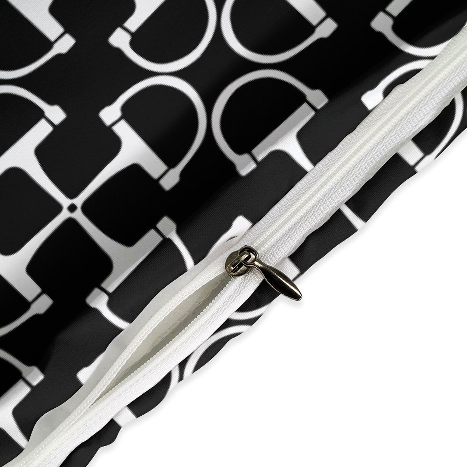 Close-up of a white strap with a metal buckle against a black and white patterned background.